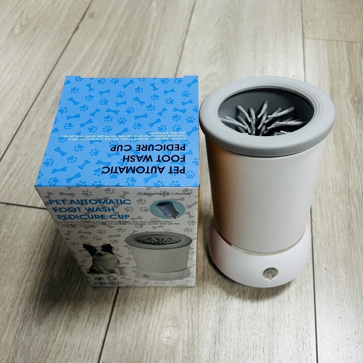 Automatic dog paw cleaner shown with its retail packaging, an electric paw washer cup for dogs and cats