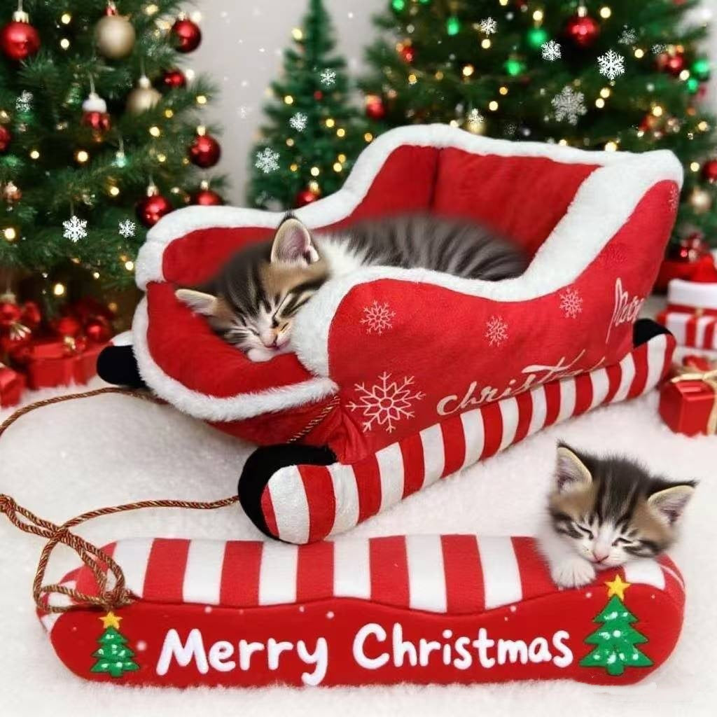 Red velvet Christmas sleigh-shaped pet bed with white fur trim and candy-cane striped rails, shown with a kitten curled up inside next to decorated Christmas trees